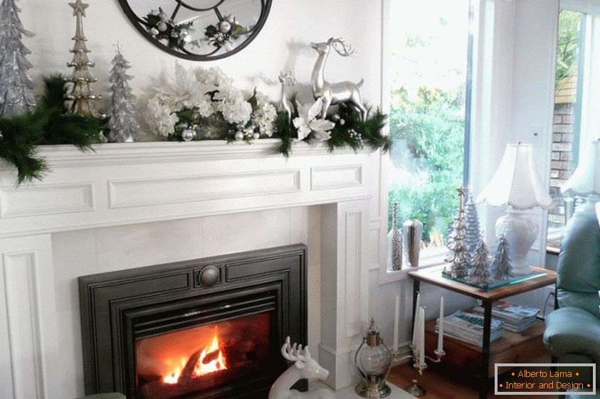 White-silver decoration of the living room with a fireplace for the new year