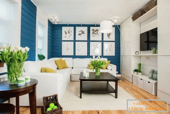 White sofa in the interior with blue wallpaper and wooden floor