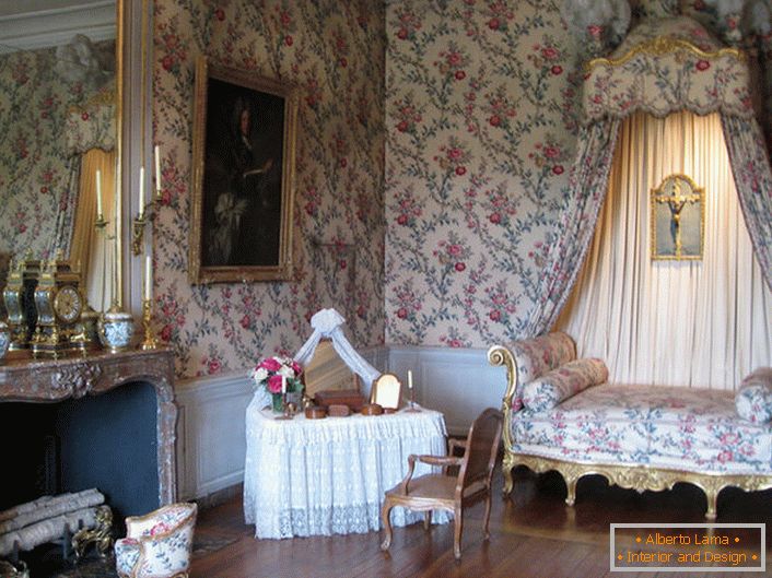 The colorful decoration of the walls is in harmony with the upholstery of the sofa and canopy over it. A baroque lounge with a large fireplace is a great idea for a country house.