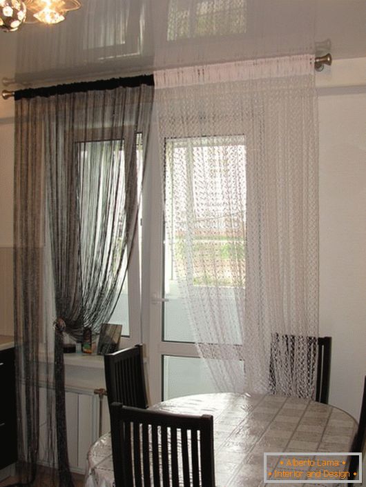 Original curtains in the classic combination of colors black and white in the interior of the kitchen of medium size.