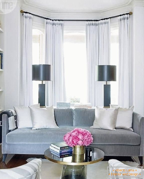 A small sofa is conveniently located in the bay window