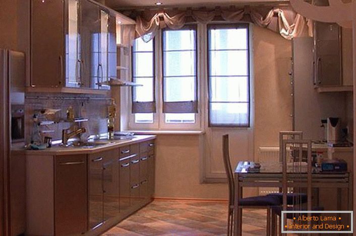 A spacious kitchen set with hanging cabinets in light beige tones looks attractive and exquisite. Instead of a pantry, the designer made a niche, where for convenience was placed a refrigerator.