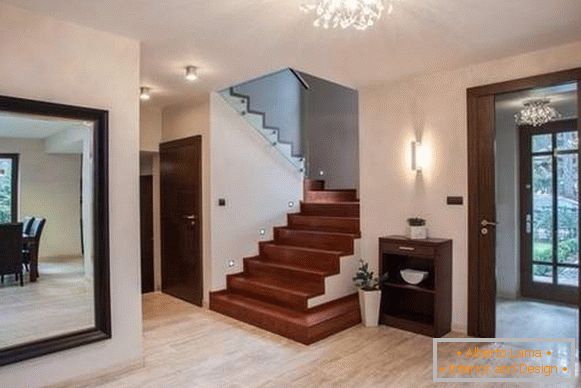 Design of the hallway in a private house with large mirrors and stairs