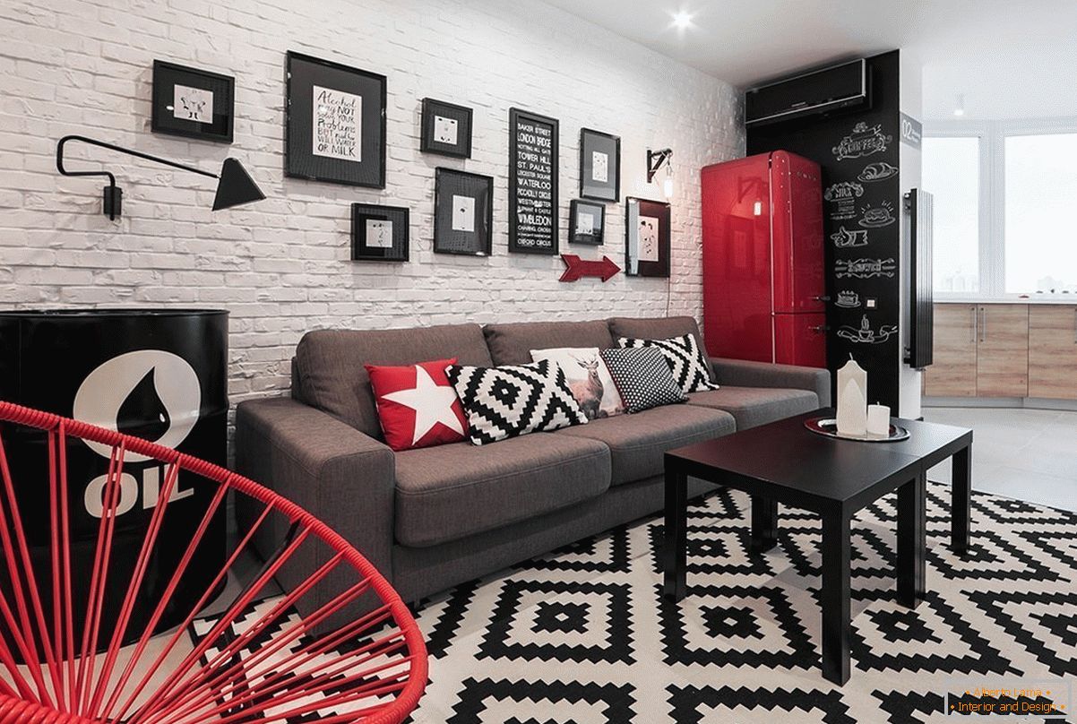 Red decor elements in a black and white studio apartment