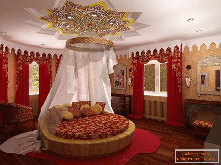 In the center of the composition is a round bed under the canopy. Attention attracts the ceiling, which is interestingly decorated over the bed.