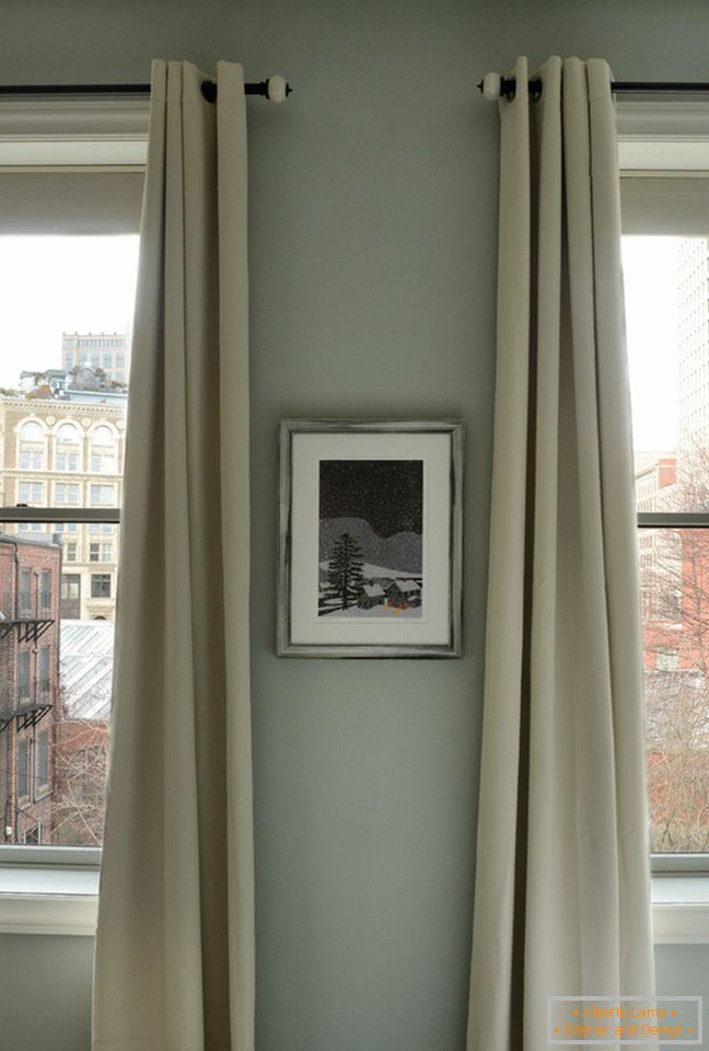 Interior of a small apartment: long curtains on the windows