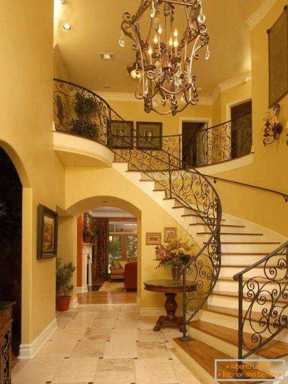 Large forged chandelier in front of stairs in the hall