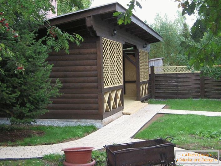 A dark gazebo made of wood in the style of a chalet is a popular choice for modern suburban real estate owners.