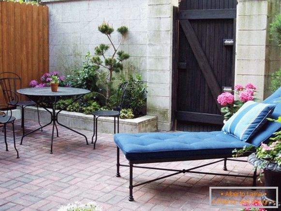 Patio with a couch and wrought-iron furniture