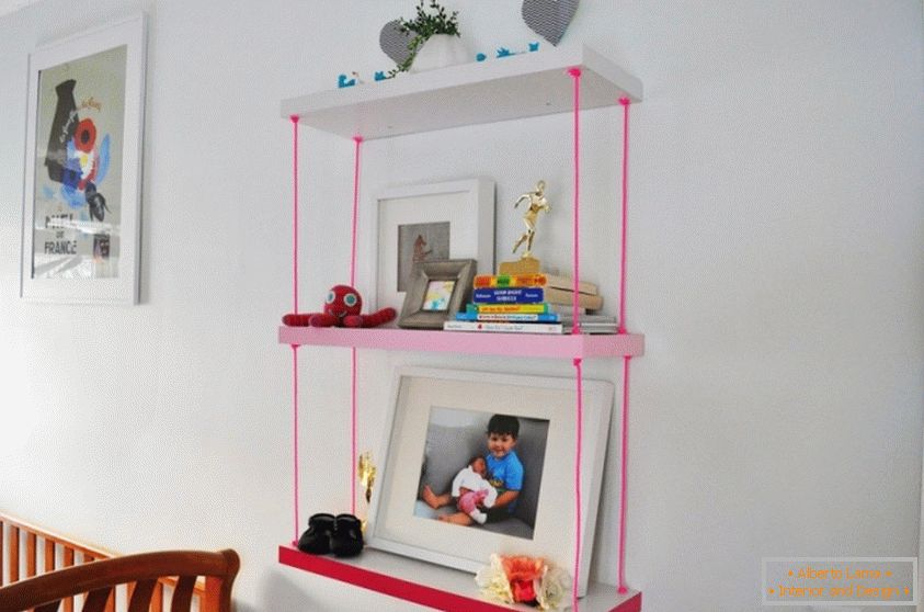 A bookshelf for a children's room with pink ropes