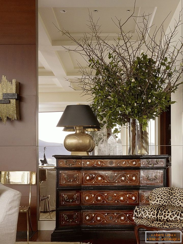 A large mirror in the wall behind the chest of drawers