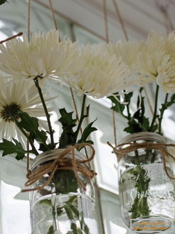 White flowers in cans on the window