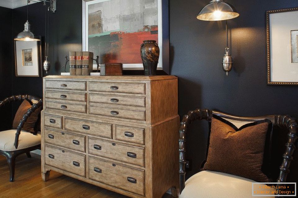 Wooden chest of drawers against the backdrop of black walls