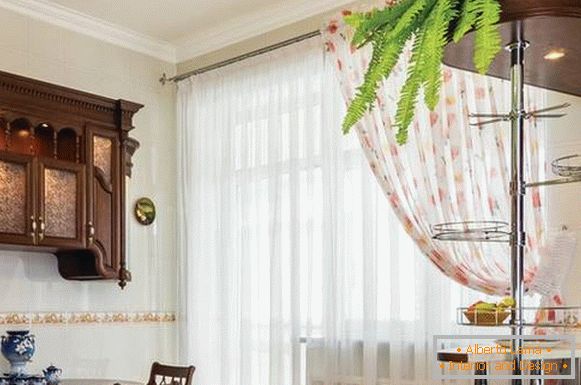Transparent curtains in the interior of the kitchen with balcony