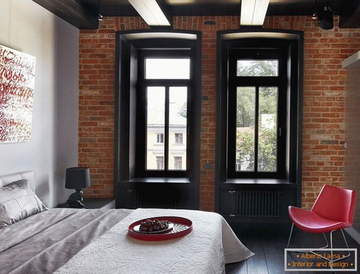 A successful combination of classic colors-white, red, black in the interior of the bedroom loft style.