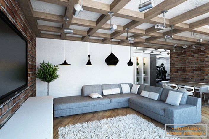 Cozy bright living room in loft style. Harmonious combination of masonry brick walls and massive beams. 