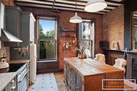 Gray furniture for kitchen in loft style with a brick wall
