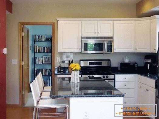 White kitchen with a red wall and a bar counter