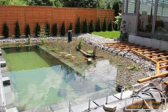 Shallow pond or pool on the plot with your own hands photo