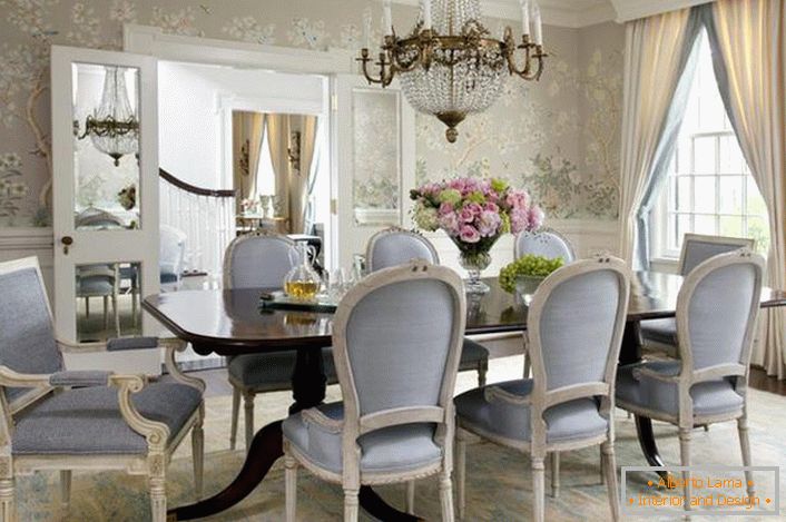 The dining room in the Neoclassic style is decorated in pale blue and light gray colors. Flower wallpaper gently look in combination with white high plinths.