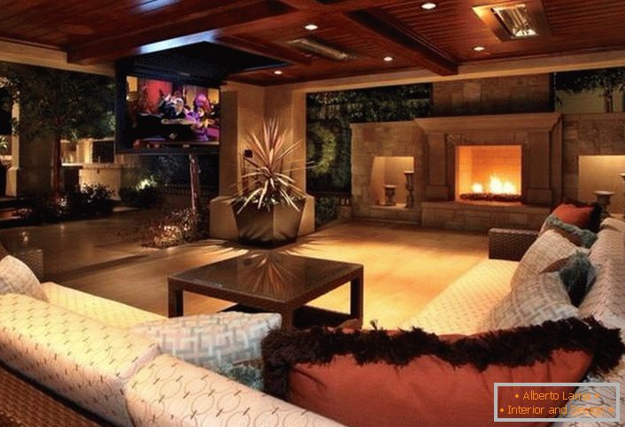 A stylish guest room in a modern rustic style is decorated with a large fireplace. Wooden ceilings are organically fit in the overall interior.