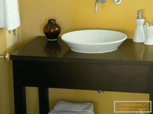 A table of a curbstone under a sink in a bathroom the hands