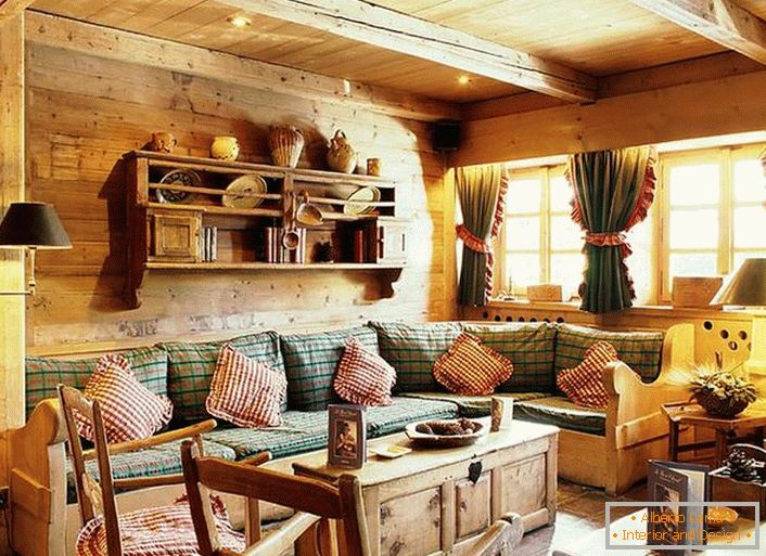 Wooden wall decoration, contrasting pillows on a soft sofa, dense curtains with ruffles on the windows. Cozy living room in a rustic style in a country house.