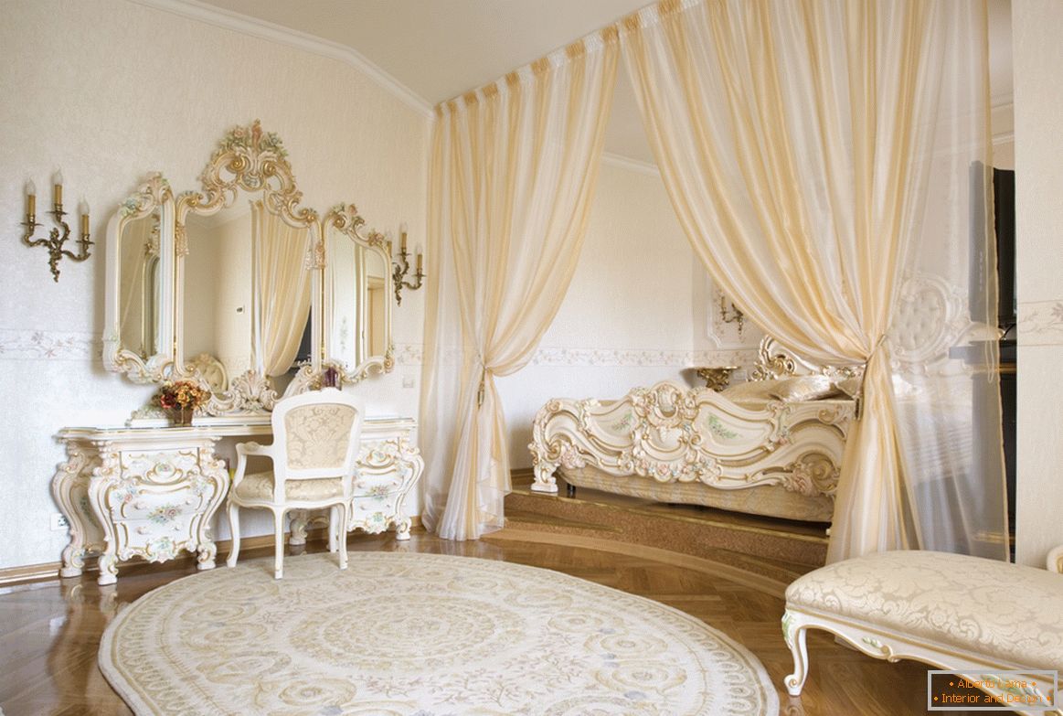 Framing mirrors and decorative elements of furniture are made in one style with the use of gold. To save space, the bed is hidden in a niche framed by curtains.