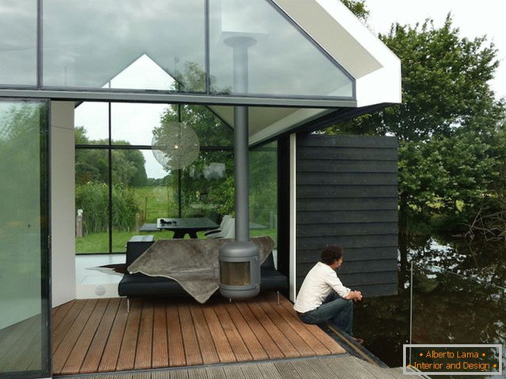 Terrace of a small glass house by the lake in Holland