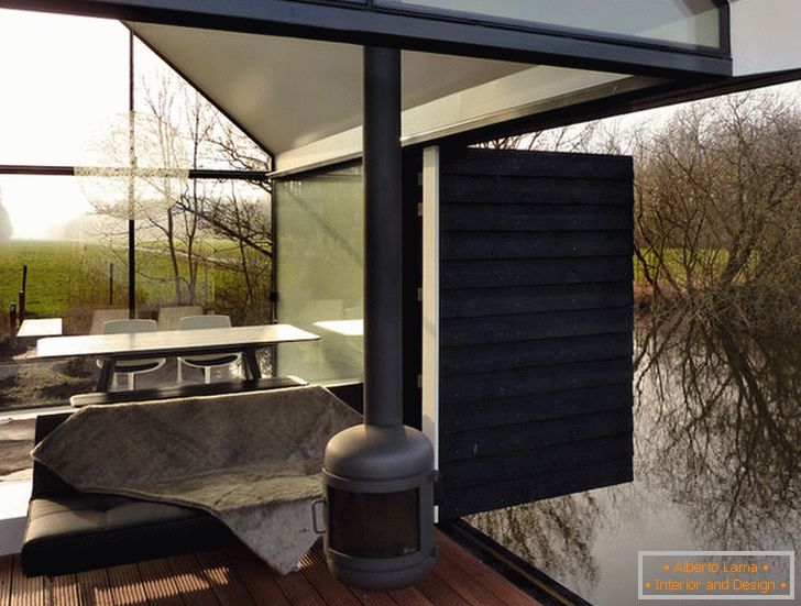 Terrace of a small glass house by the lake in Holland