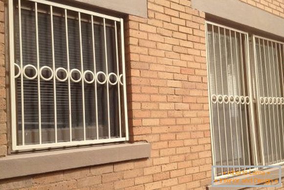 Welded metal grilles on windows in white color