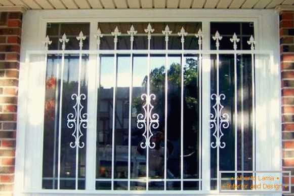 Beautiful grilles on the windows of a private house made of bricks