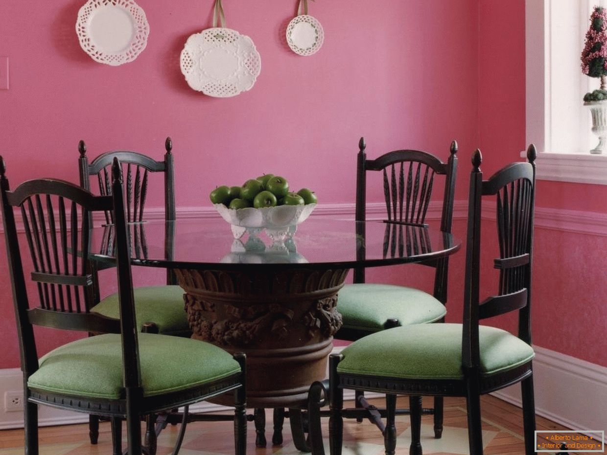 The combination of green chairs in a pink dining room