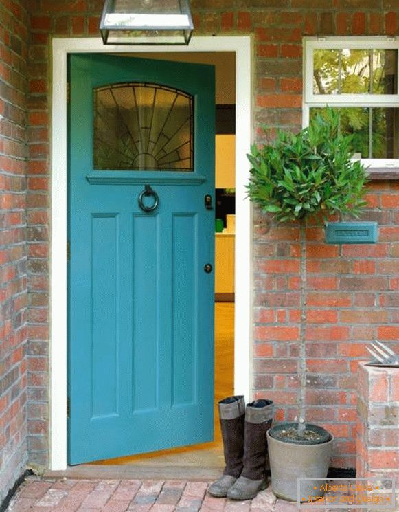 Blue entrance doors to a red brick house