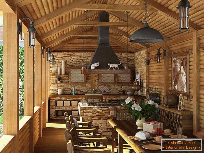 A small kitchen with a barbecue on the veranda of a country house. The country style is evidenced, first of all, by the decoration of the walls and ceiling with a wooden frame.