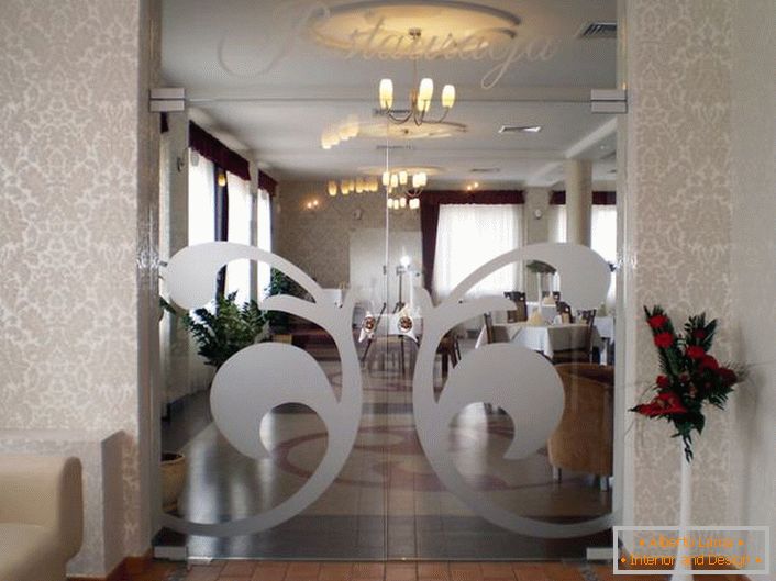 Glass doors in the Art Nouveau style are decorated with a silvery symmetrical ornate pattern. An original detail for a modern interior. 
