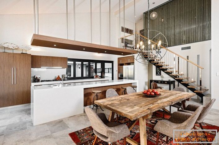 A stylish kitchen in loft style is not overloaded with details. A functional and practical kitchen set divides the space into a working and dining area.