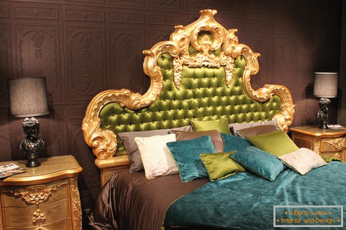 A high ornate back in the head of the bed is covered in olive silk. Interesting pillows of contrasting colors and bedspreads on the bed.