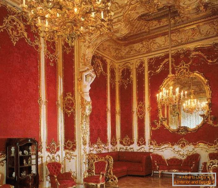 The living room in the house is properly decorated with red furniture. Noble red is perfectly combined with gold trim elements.