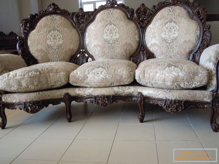 Ornate edging of the back, carved legs, textile upholstery - the perfect choice for a baroque style living room.