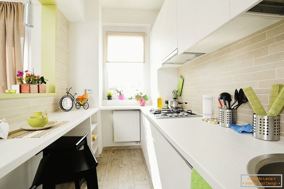 Long white kitchen with light green accents
