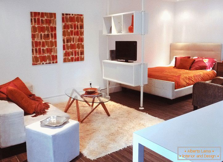 Interior of a white studio apartment with orange accents