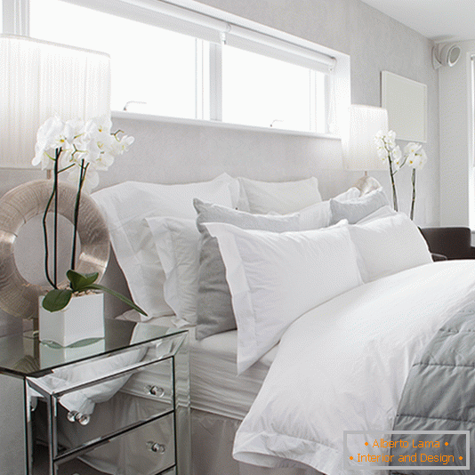 A dazzling white bedroom with a beautiful light
