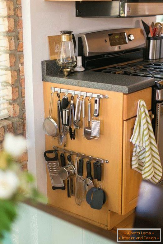 Hooks for kitchen utensils on the side of the cabinet