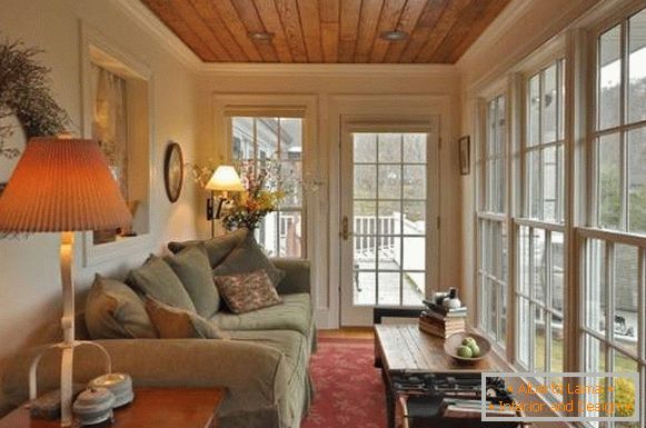 Glazed veranda with a large sofa and lamps