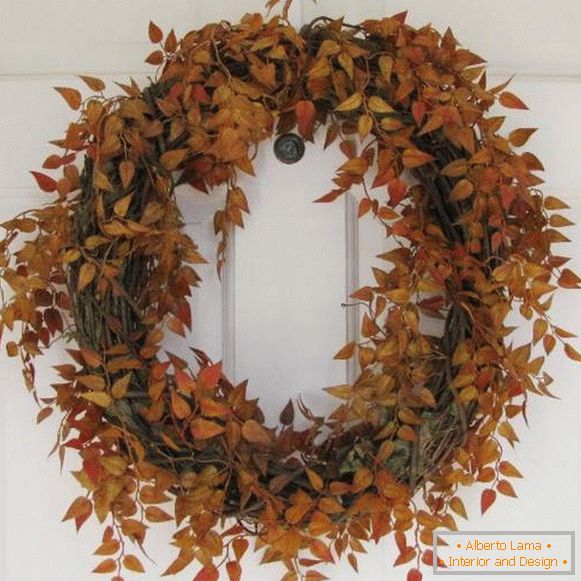 Natural autumn wreath with your hands on the front door