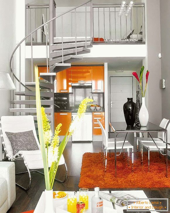Interior of the apartment with a spiral staircase to the second level above the kitchen