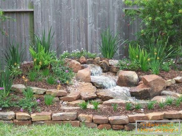 Small artificial waterfall and alpine slide in the garden