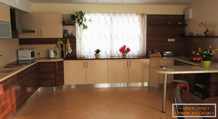 A pleasant large kitchen in light beige tones with mahogany accents of comfortable furniture.