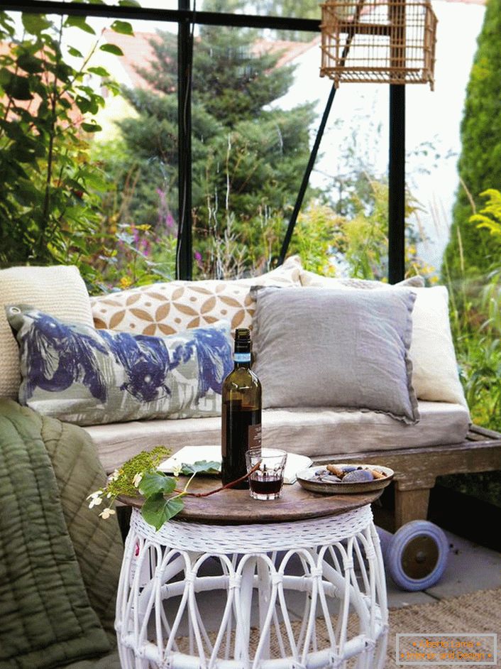 The best decor of a gazebo in the Scandinavian style is a sofa with a lot of soft pillows.